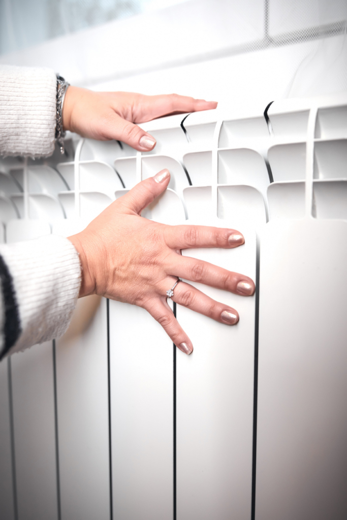 Női kéz megfogja a radiátort