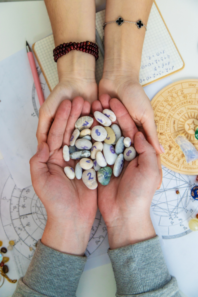 Két kéz számozott köveket tart a numerológiához