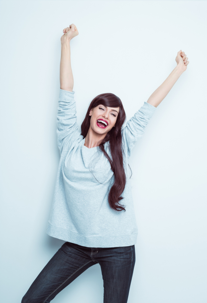 Energikus, vidám nő a magasba nyújtózik