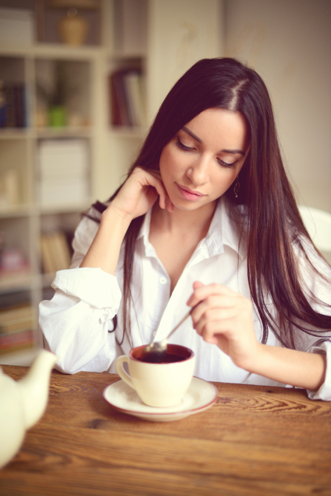 Nő kavargatja a reggeli kávéját