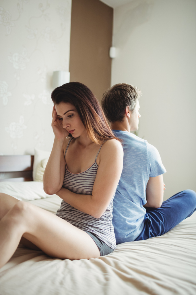 Pár ignorálja egymást - egymásnak háttal ülnek az ágyon