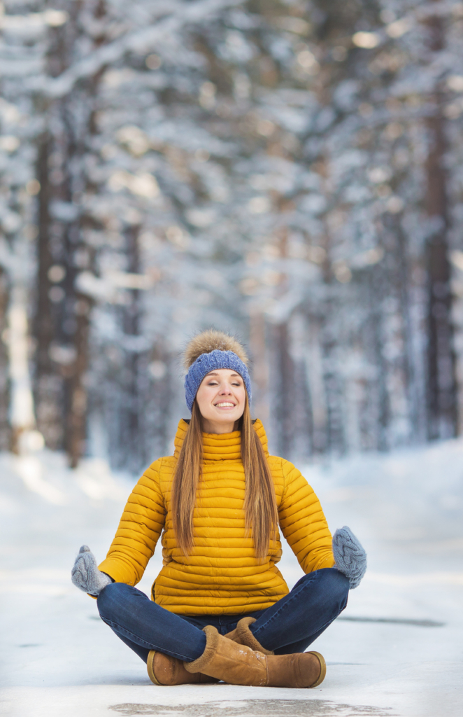 Nő a hóban ülve meditál