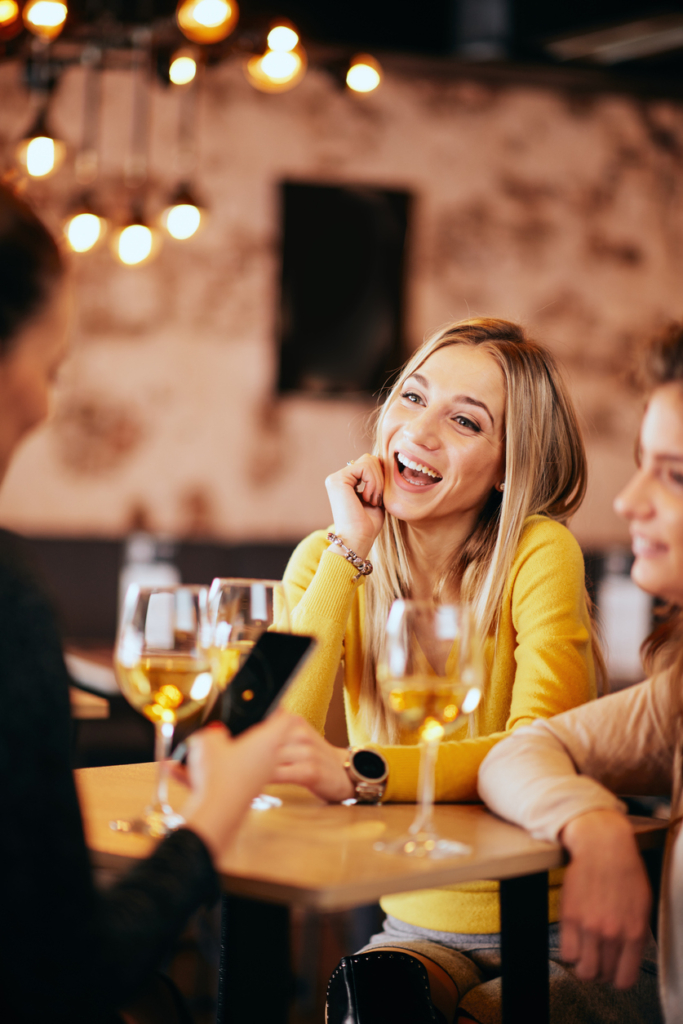 Nő a baráti társaságával beszélget és borozik