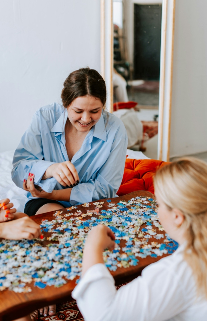 Lány a barátnőivel puzzle-t rak