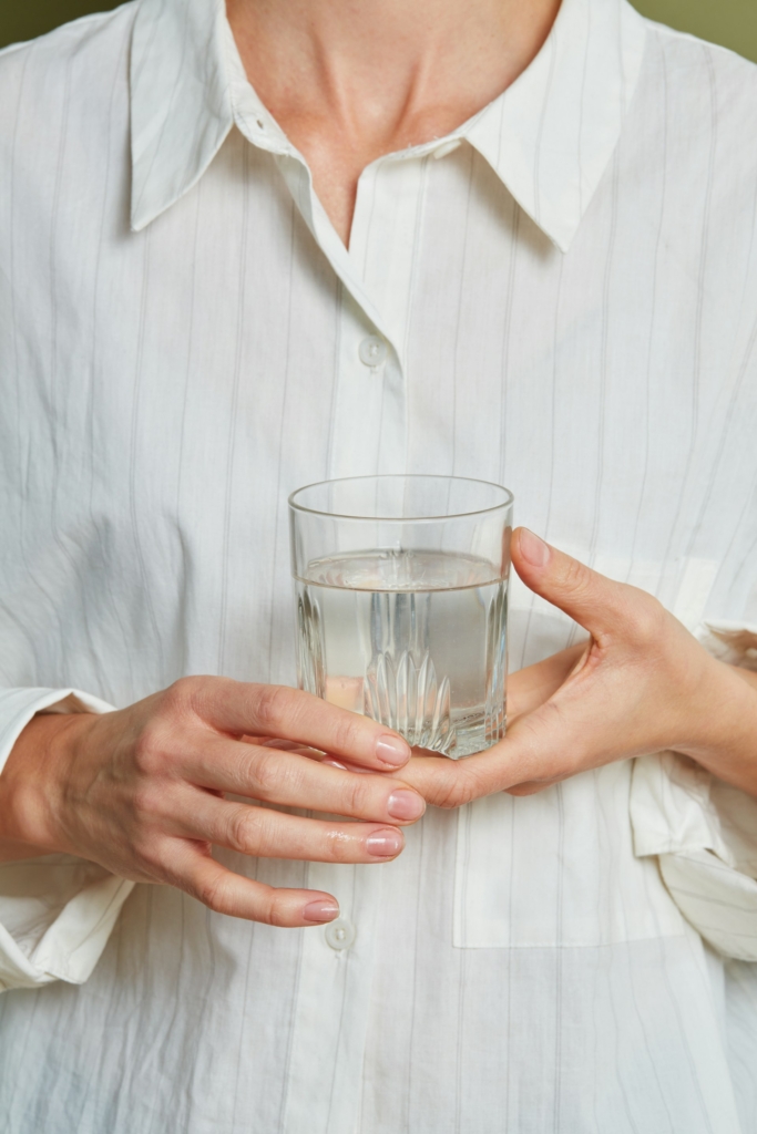 Nő egy pohár vizet tart a kezében