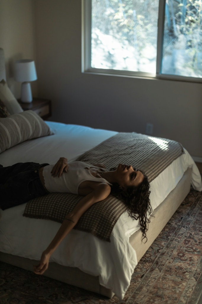 Lány összetörten, szomorúan fekszik az ágyában és bámulja a plafont