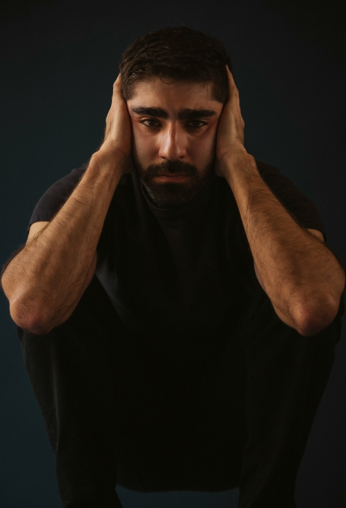 Hombre sosteniendo su rostro con las manos