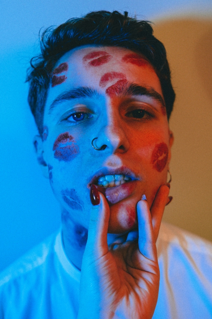 Fiatal srác arca vörös rúzzsal összecsókolgatva