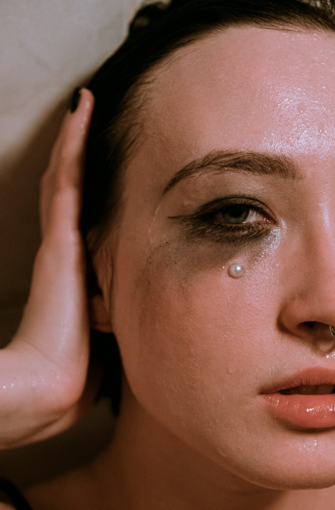 Nő portré részlet, könnyes szem elkenődött sminkkel, a szem alatt egy gyönggyel