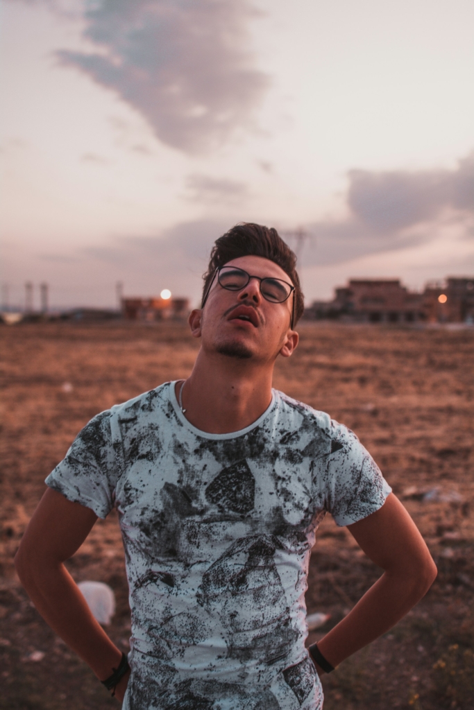 Férfi unottan áll egy kopár réten