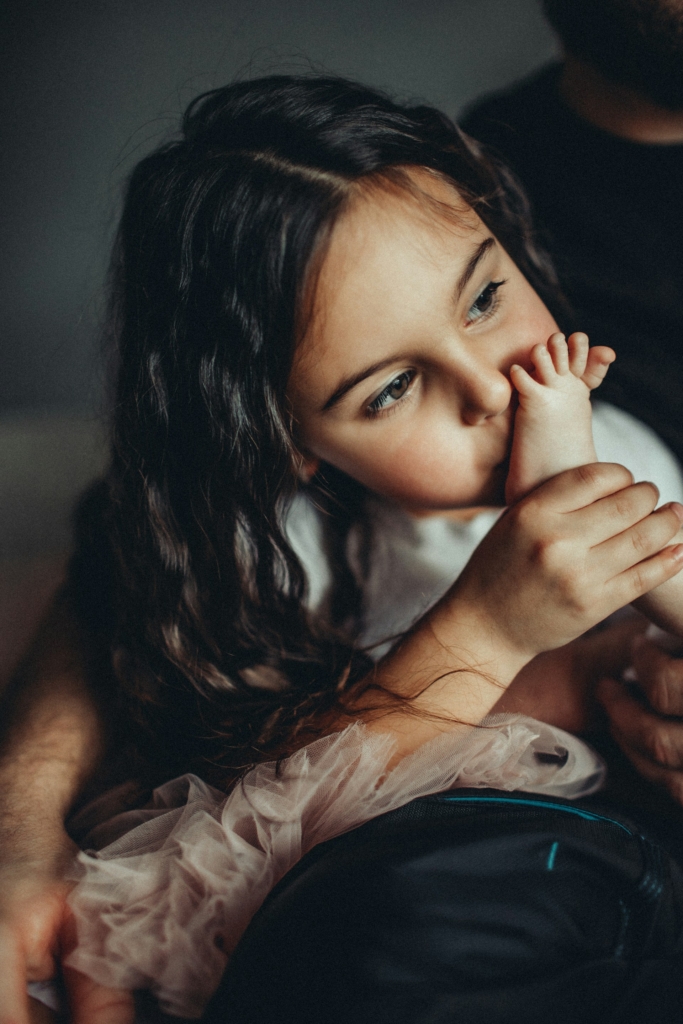 Kislány megpuszilja az öccse lábát