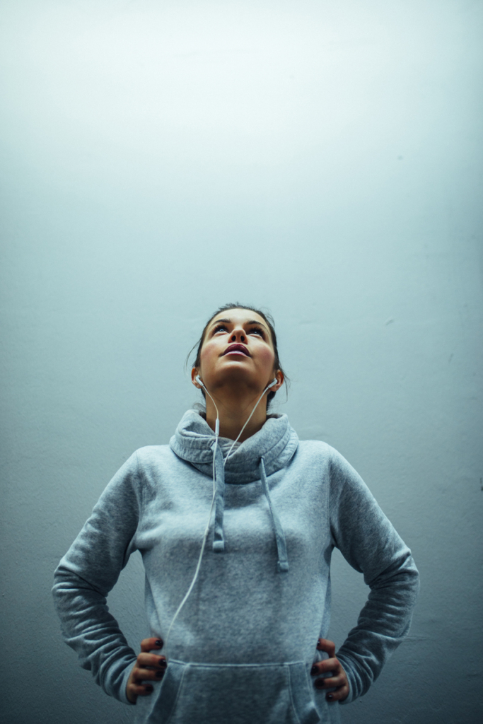 Nő sportpulcsiban, fülessel a fülében