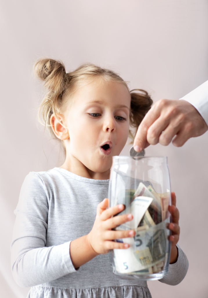 Kislány meglepett arcot vág, ahogy az anyukája bedob egy aprópénzt a perselyébe