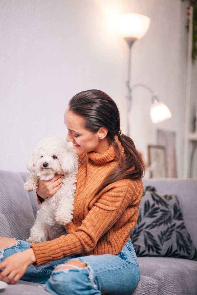 Nő a kiskutyájával játszik