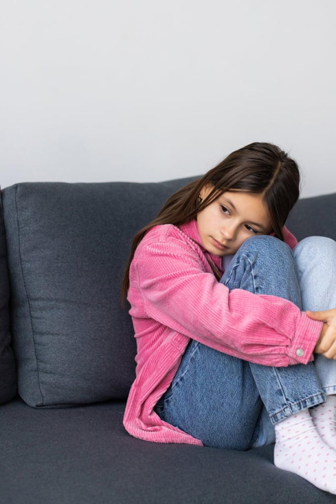 Kiskamasz lány sértődötten ül a kanapén