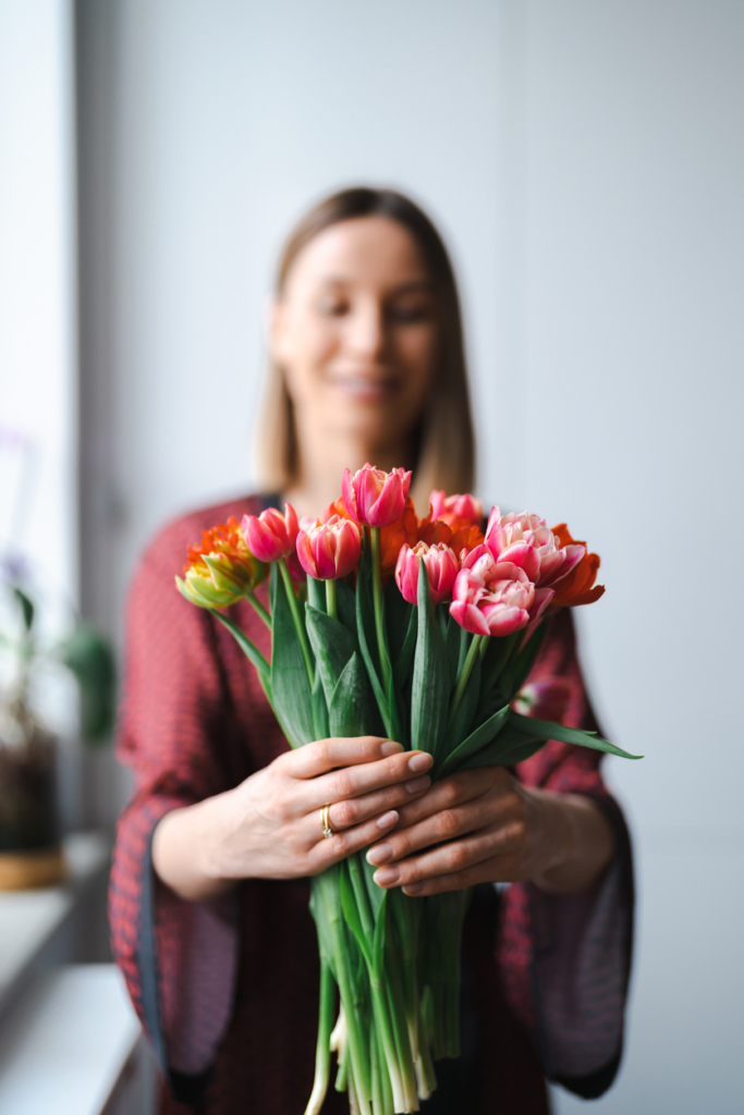 Nő egy csokor tulipánnal a kezében