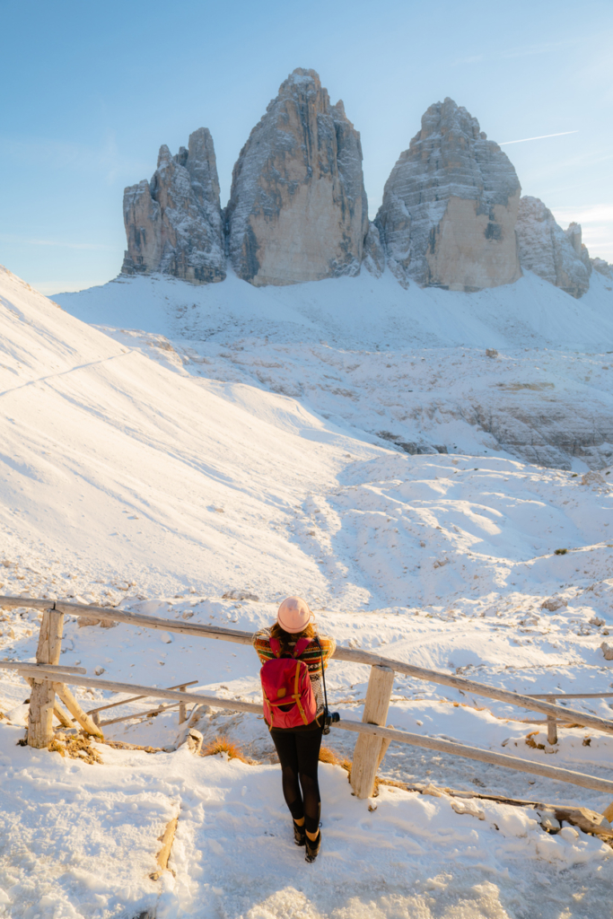 Nő áll a havas Tre Cime di Lavaredo lábánál