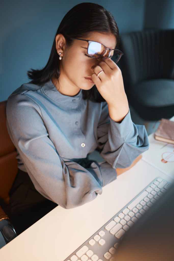 Stresszes, szorongó nő a számítógép előtt ül a munkahelyén