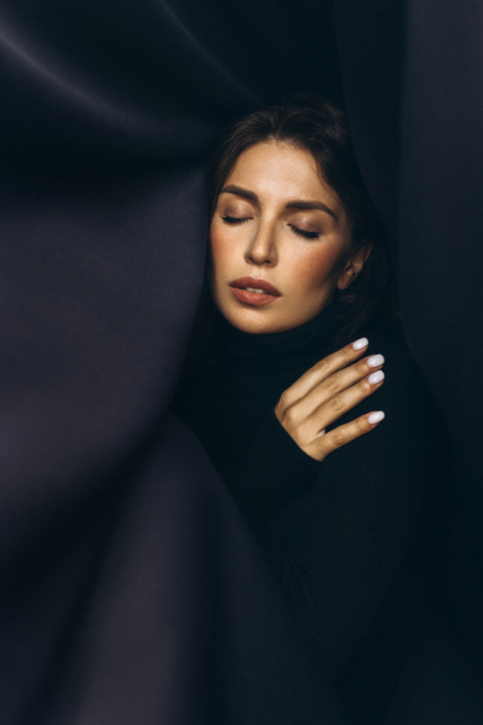 Nő egy fekete selyem lepedőbe burkolva