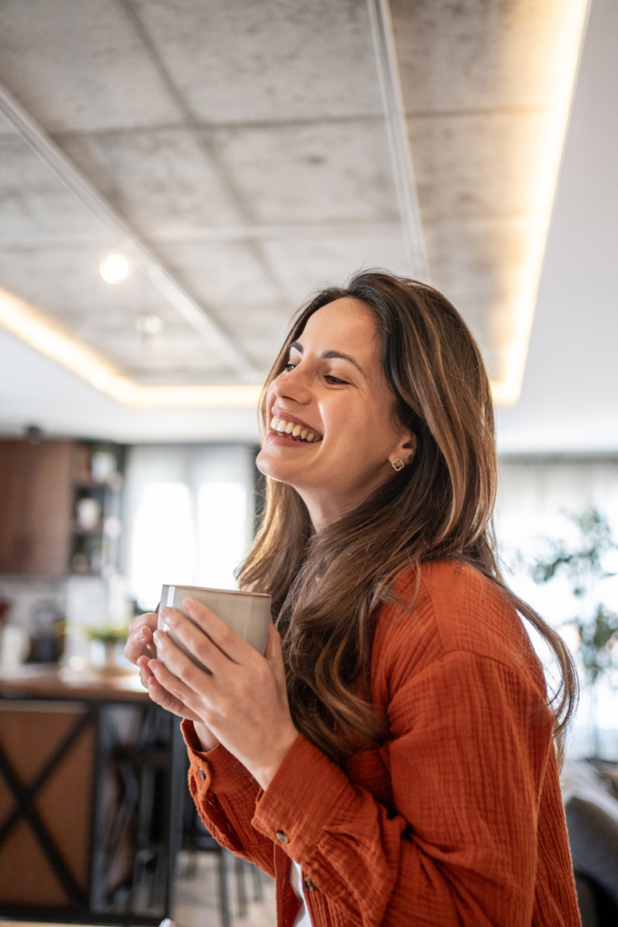 Vidám, mosolygós nő kávézik