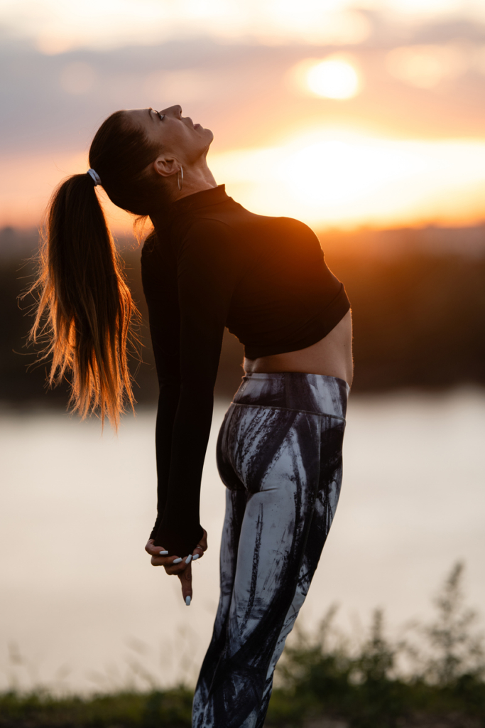 Nő a naplementében tornázik