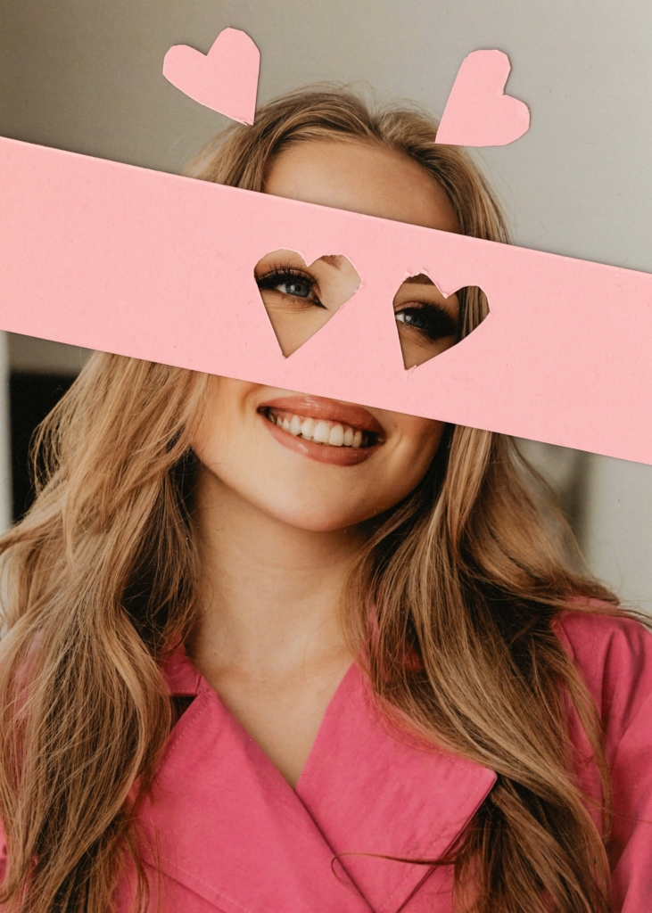 Nő a szeme előtt egy papírral, amiből szív formák lettek kivágva