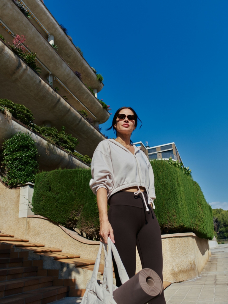 Nő jógafelszerelésben a lakása előtt