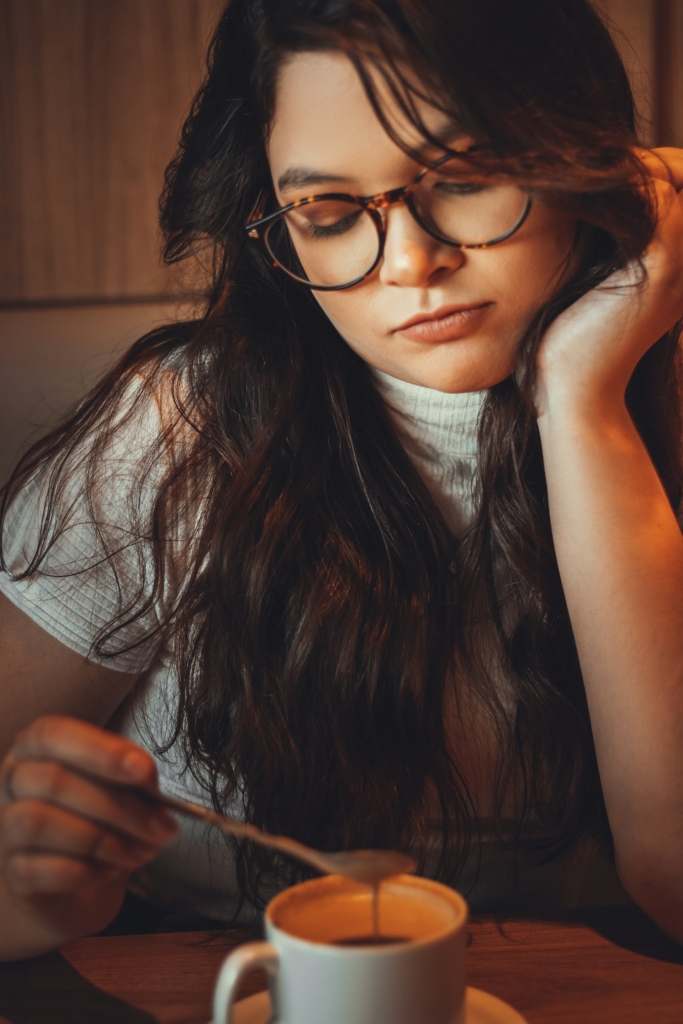 Lány kavargatja a kávéját