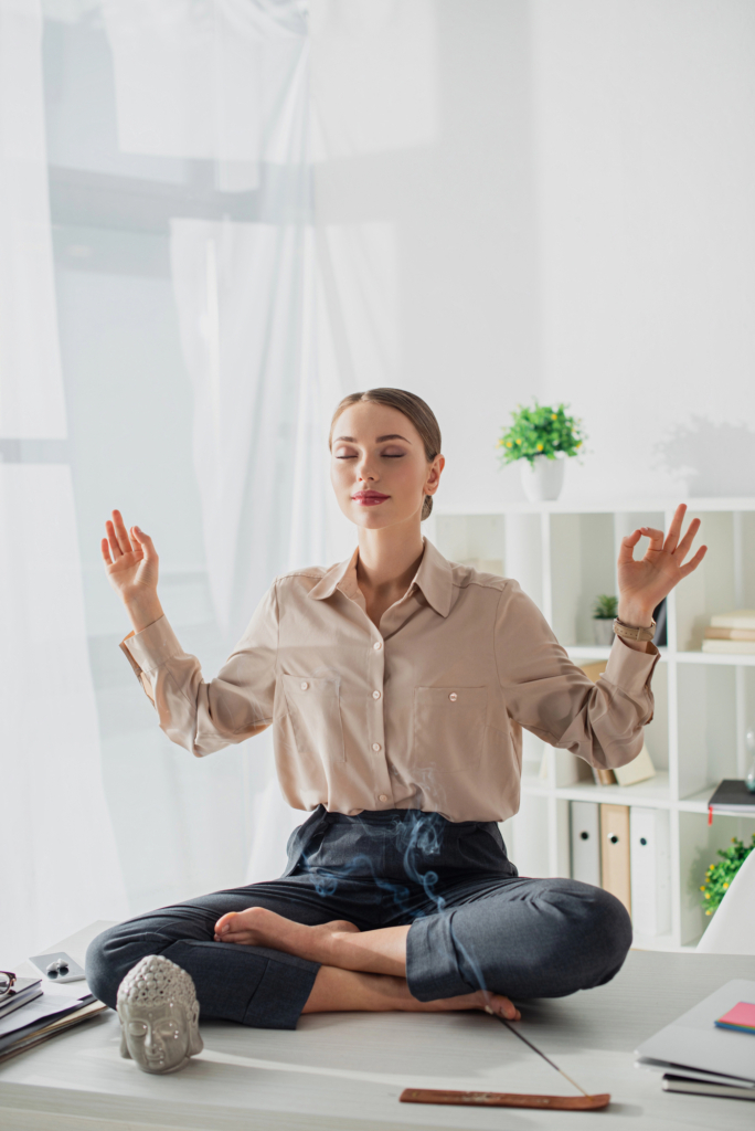 Nő a munkahelyén meditál az asztalon