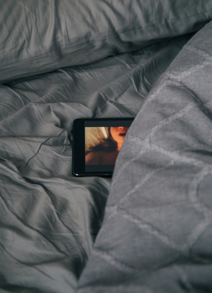 Pornófilm megy egy kis méretű tableten a takaró alá rejtve
