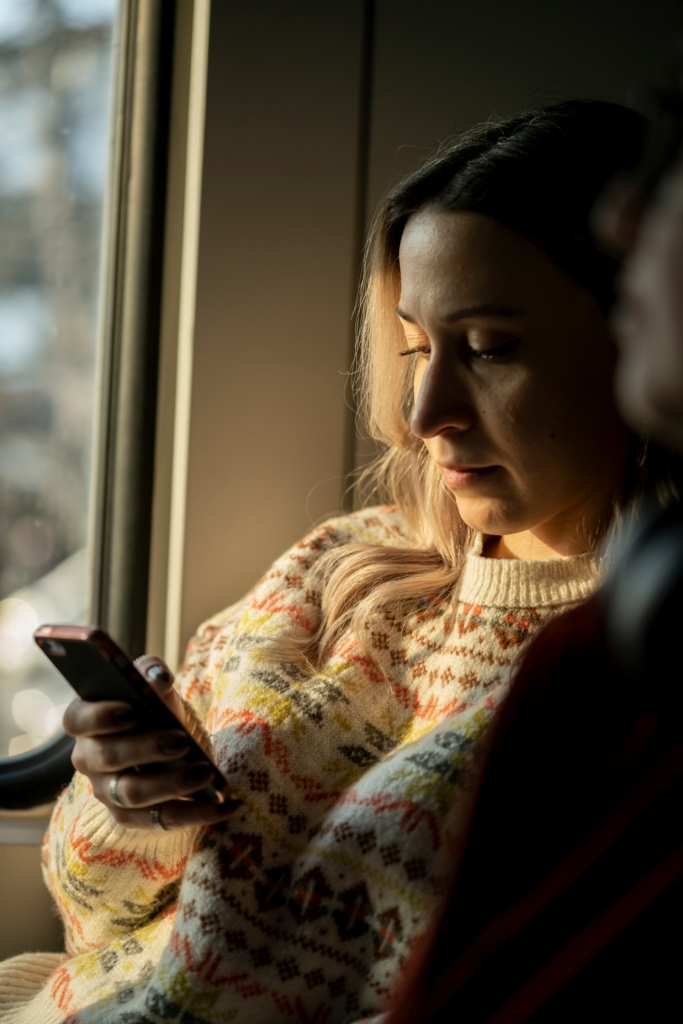 Nő szomorúan görgeti a telefonját