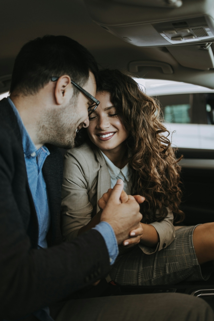 Pár az autóban fogja egymás kezét