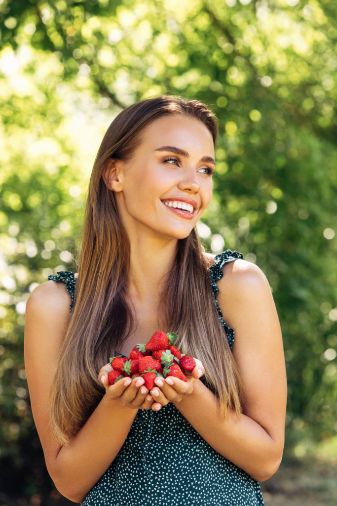 Nő egy pár szem epret tart a tenyerében