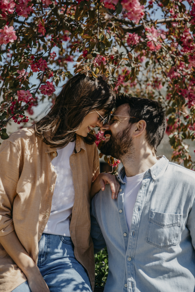 Couple in love cuddling under a blooming tree in spring