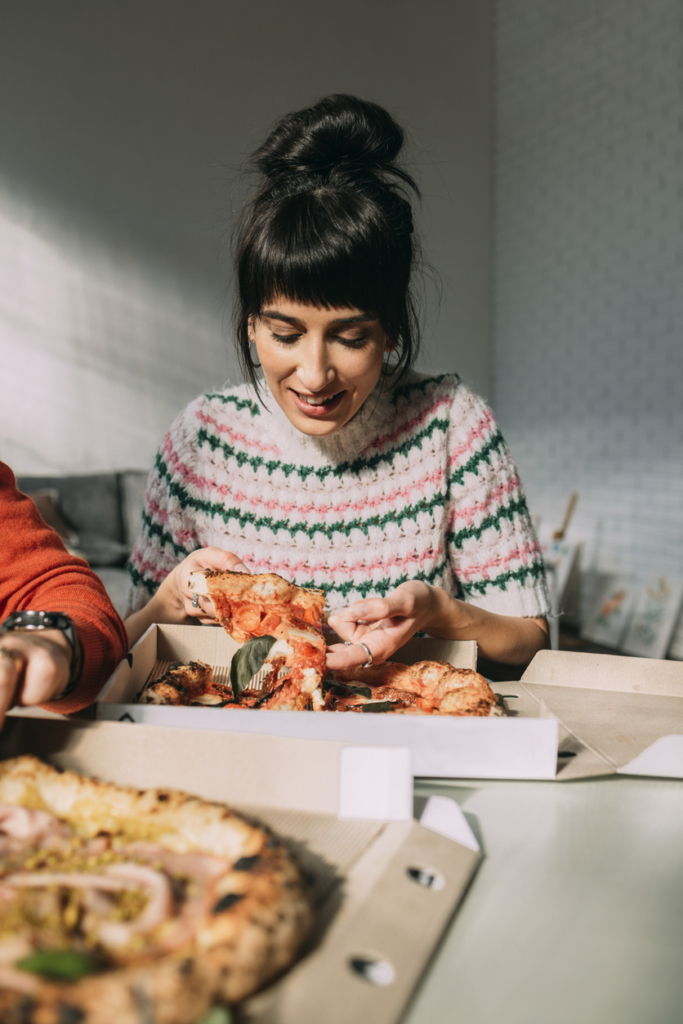 Nő pizzát eszik dobozból