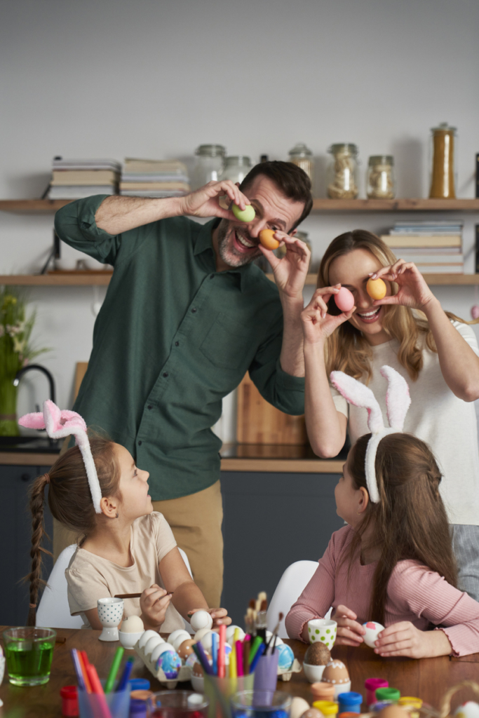 En famille à Pâques : papa, maman et les enfants peignent des œufs