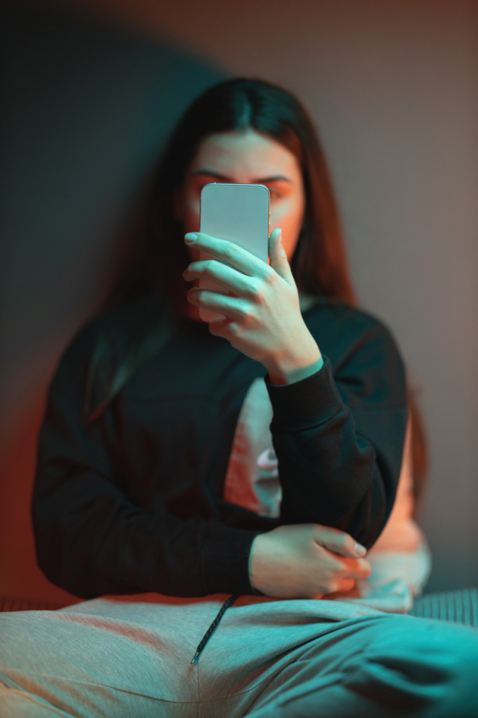 Nő a mobilján olvasgat este