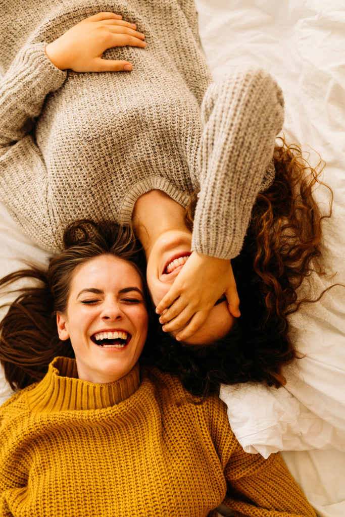 Tinédzser korú lánytesók együtt nevetnek