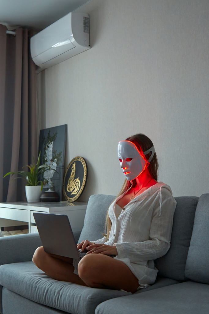 Frau trägt zu Hause LED-Lichttherapie-Gesichtsmaske