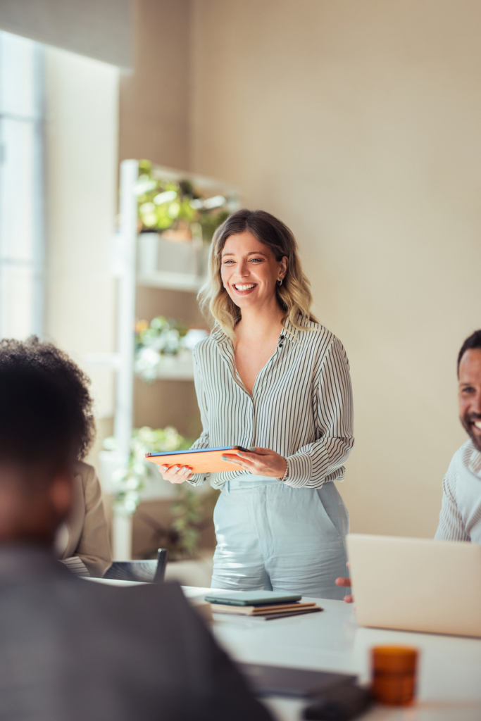 Magabiztos, de közvetlen, mosolygós üzletasszony egy meetingen