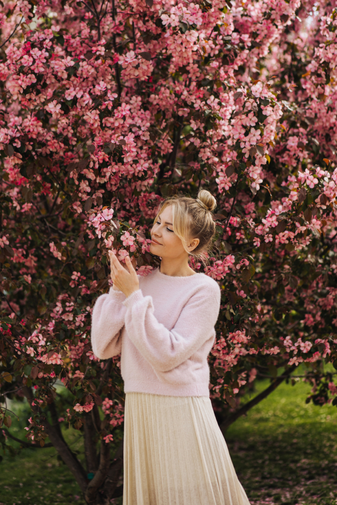 Nő rózsaszín virágzó fa mellett tavasszal