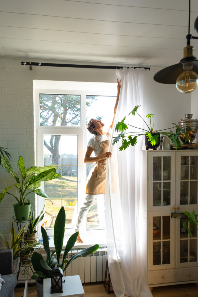 Nő leszedi a függönyöket