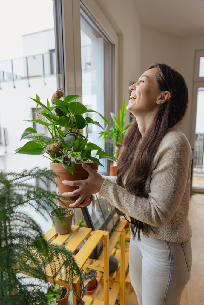 Femme arrangeant ses plantes en pot