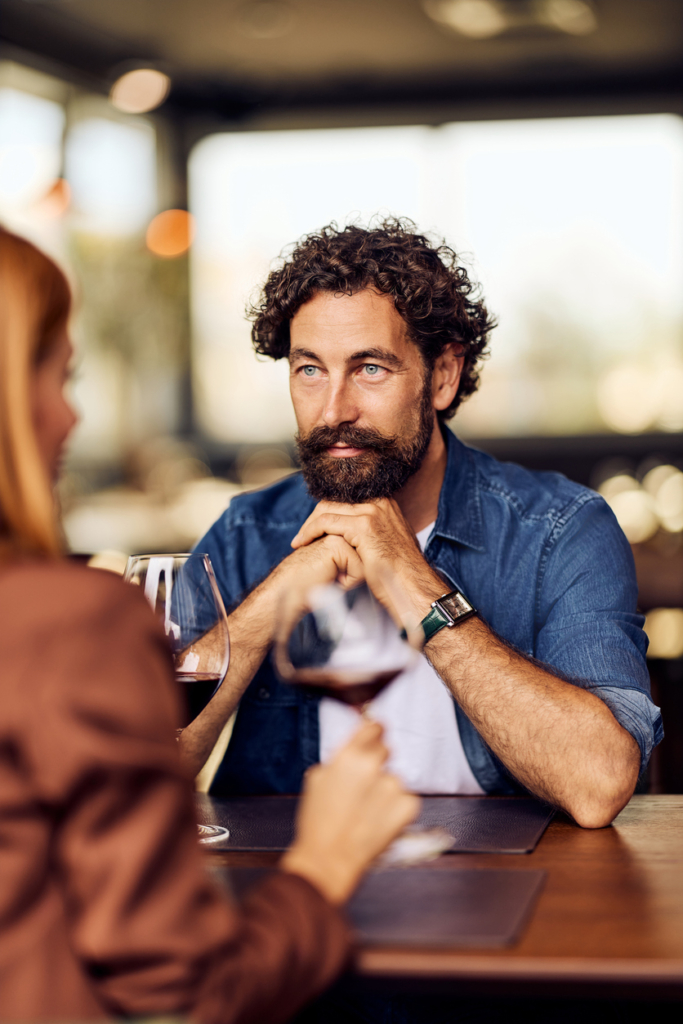 Uomo che guarda con interesse una donna durante la cena