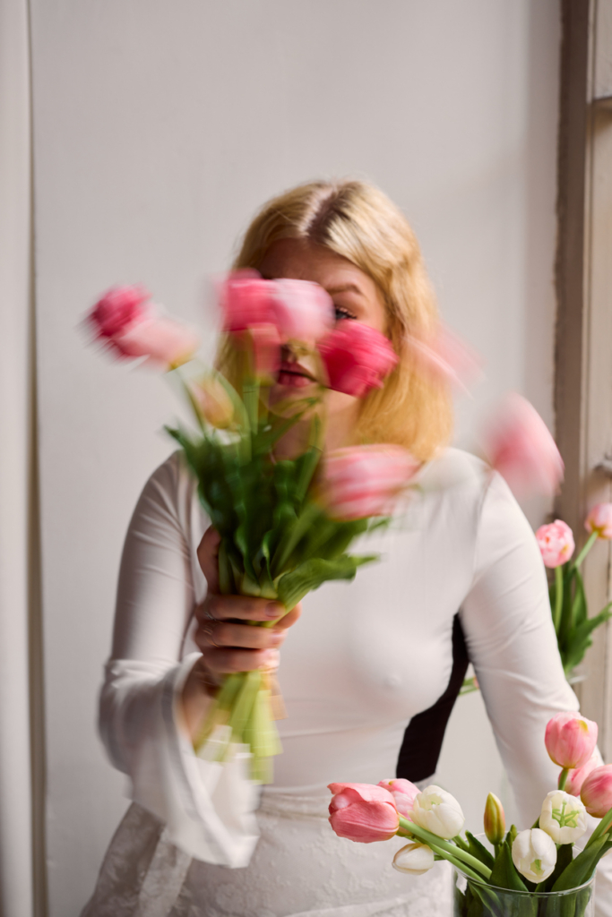 Szőke nő tulipánokkal a kezében