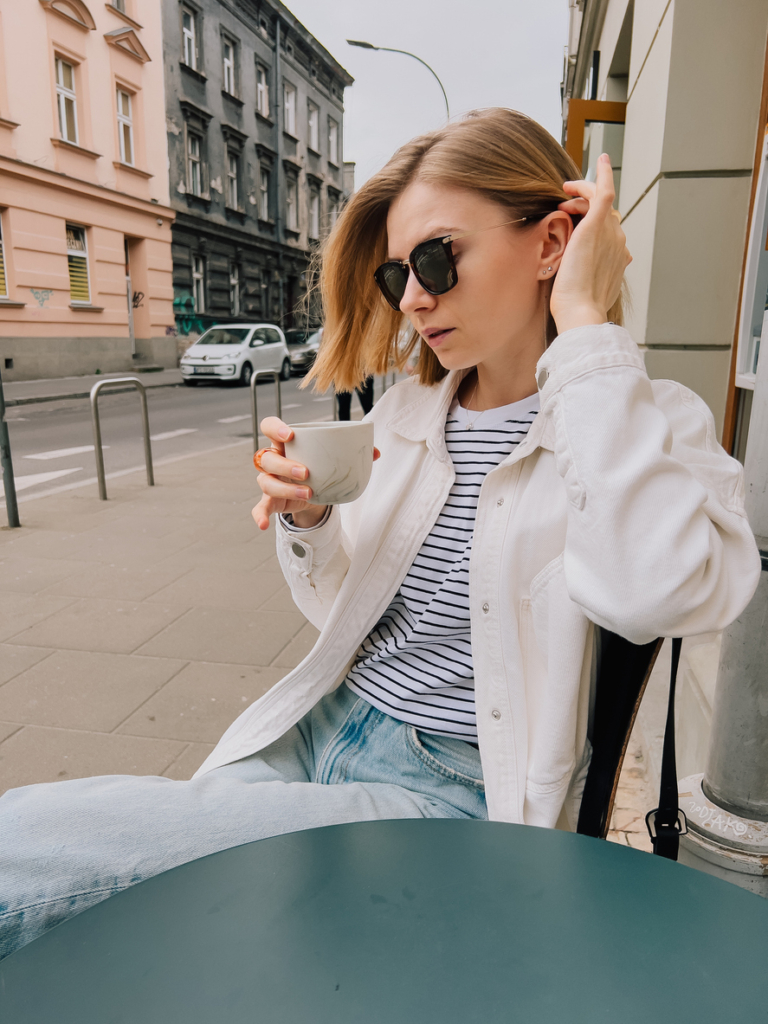 Fiatal nő egy kávézó teraszán kávézik