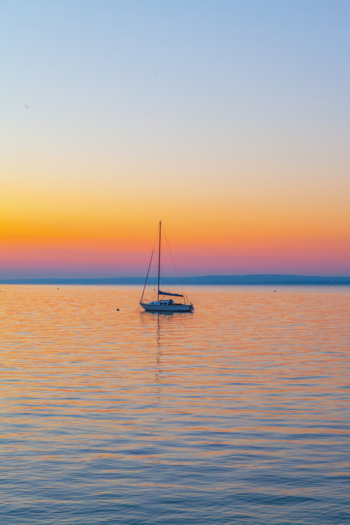 Vitorláshajó a Balatonon a naplementében