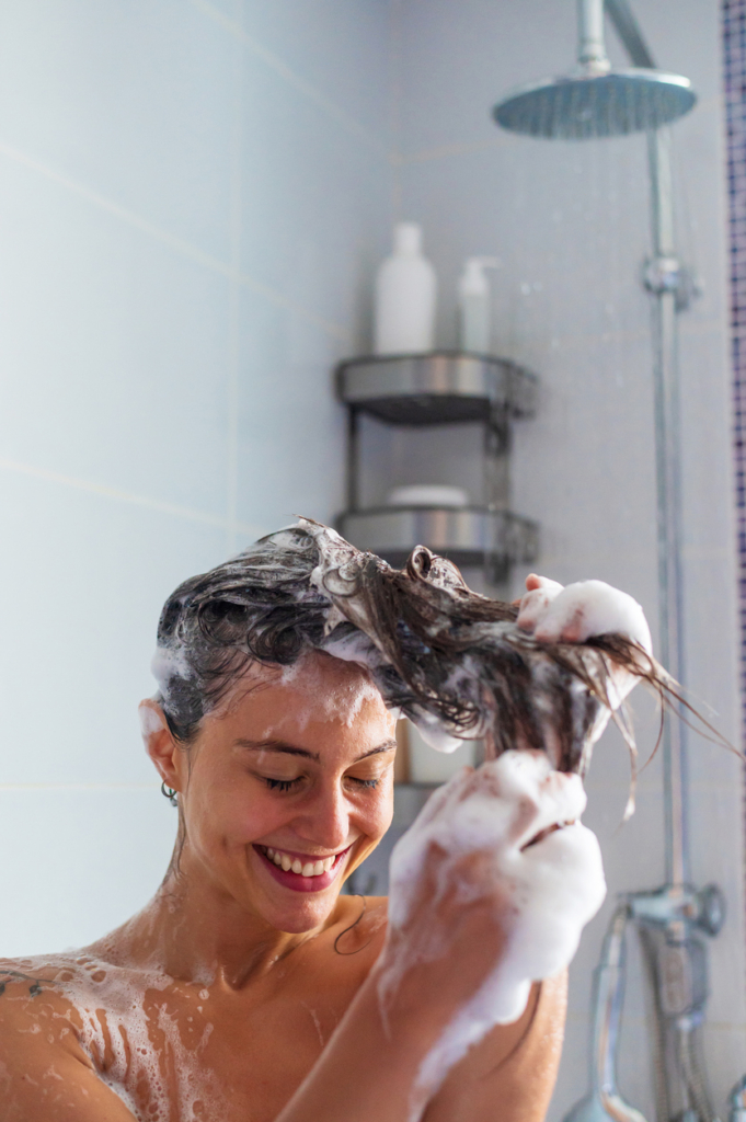 Nő hajat mos a zuhany alatt