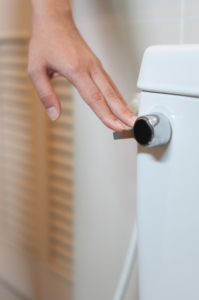 Nő lehúzza a WC-t, közeli kép