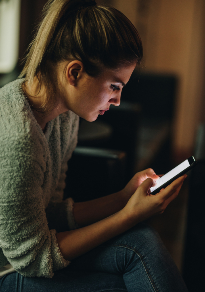 Nő egy mobilon olvassa az üzeneteket